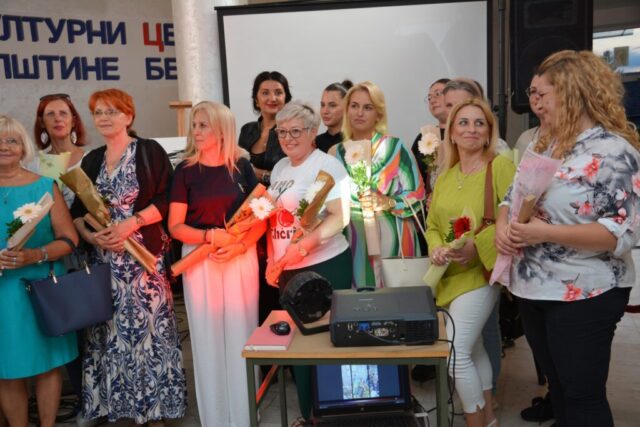 Mentorka Ljiljana Mrmoš i dve učesnice likovne radionice ispred izloženih slika na izložbi "Bljesak u oku žene" u Beočinu