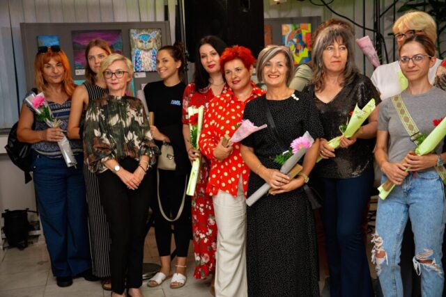 Mentorka Ljiljana Mrmoš i dve učesnice likovne radionice ispred izloženih slika na izložbi "Bljesak u oku žene" u Beočinu