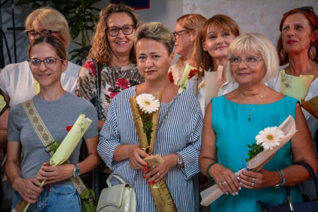 Mentorka Ljiljana Mrmoš i dve učesnice likovne radionice ispred izloženih slika na izložbi "Bljesak u oku žene" u Beočinu